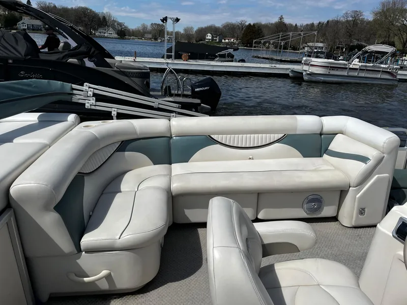 Slide: The Image of 2008 Sweetwater SW2186RE4 pontoon boat interior with white seating, docked on a calm lake. - 7