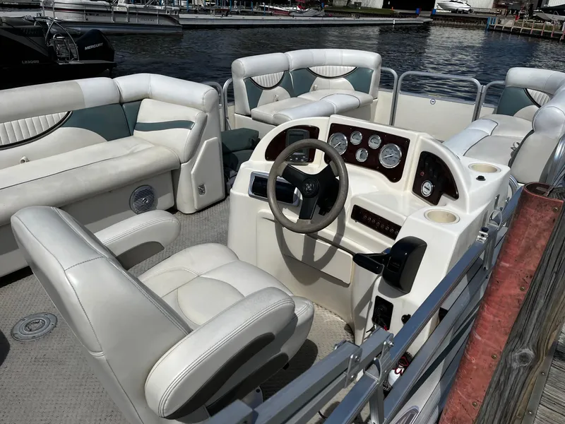 Slide: The Image of Interior of a 2008 Sweetwater SW2186RE4 pontoon boat with white seating and control panel. - 8