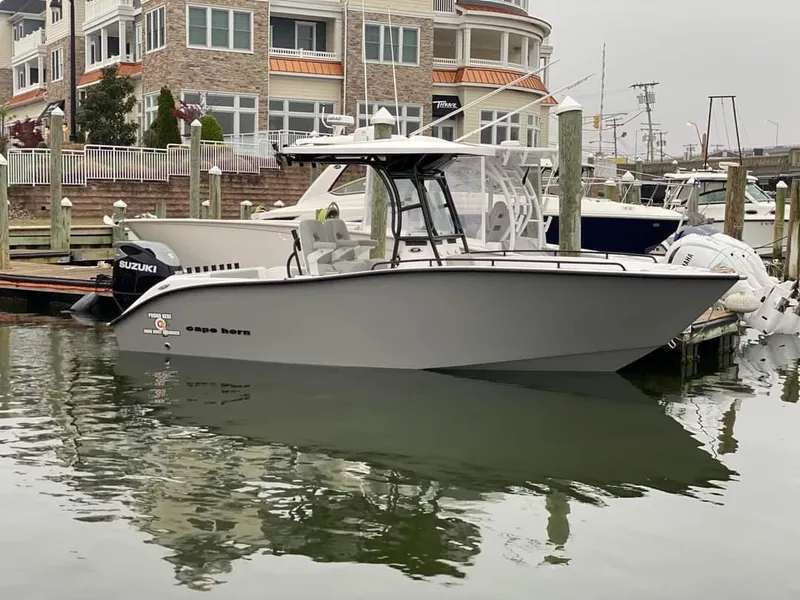 The Image of 2024 Cape Horn 22 OS boat docked in marina with Suzuki outboard motor. - 0