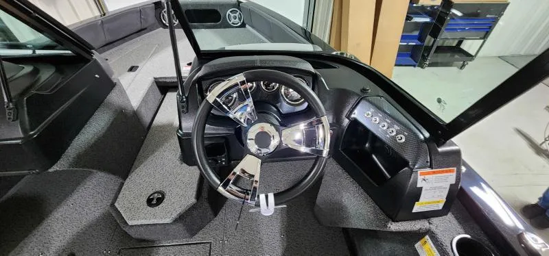 Slide: The Image of 2023 Lowe Fish & Ski 18 boat dashboard with steering wheel and control panel. - 7