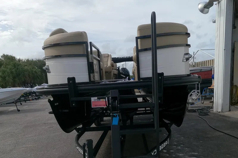 Slide: The Image of 2023 Regency 230 DL3 pontoon boat on trailer at a marina. - 11