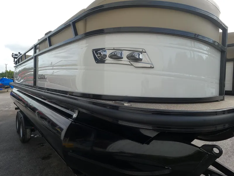 Slide: The Image of 2023 Regency 230 DL3 pontoon boat, sleek design, black and white exterior. - 4