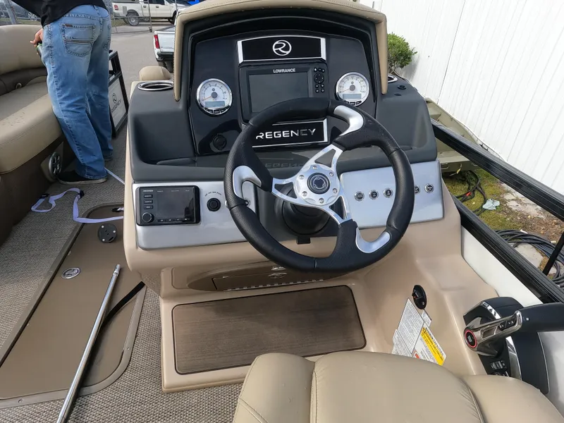 Slide: The Image of 2023 Regency 230 DL3 boat dashboard with steering wheel and control panel. - 6