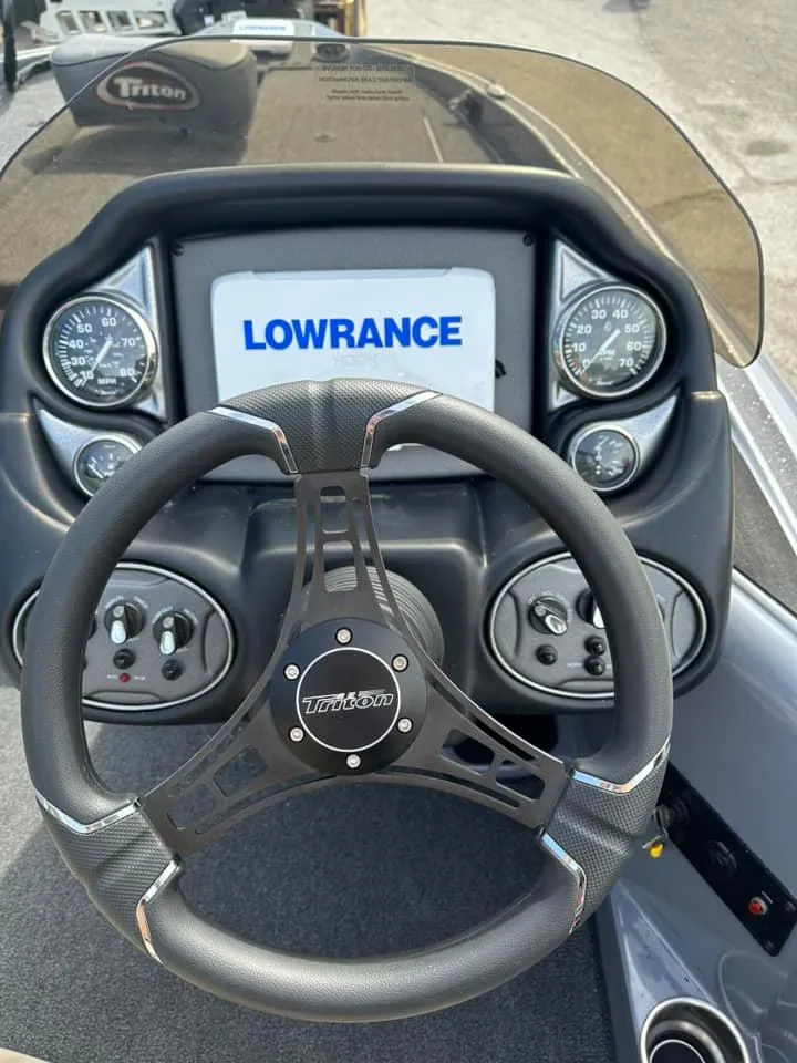 Slide: The Image of 2024 Triton 179 TrX boat dashboard with Lowrance display and steering wheel. - 4
