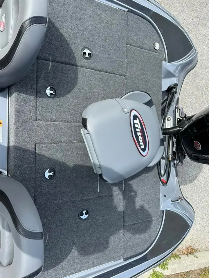 Slide: The Image of 2024 Triton 179 TrX boat interior with gray seats and carpeted deck. - 5