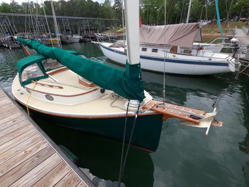 Slide: The Image of 1977 Marshall 22 sailboat docked at a marina, featuring green sail cover. - 13