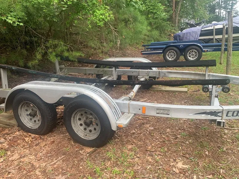 Slide: The Image of 1977 Marshall 22 boat trailer parked on grassy area with trees in background. - 17