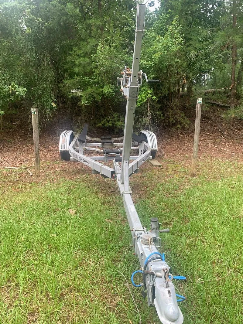 Slide: The Image of 1977 Marshall 22 trailer on grass, surrounded by trees and wooden posts. - 18