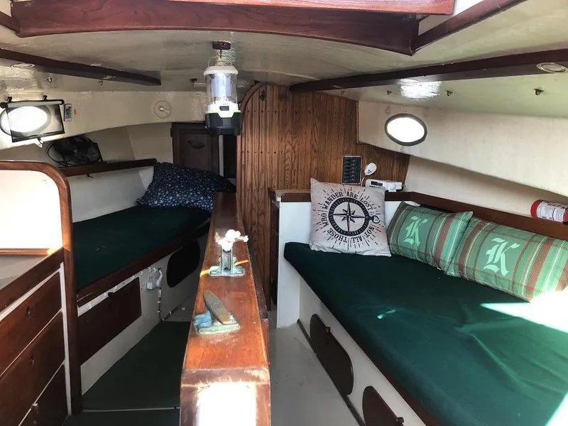 Slide: The Image of Cozy 1977 Marshall 22 boat interior with wooden accents and green cushions. - 2