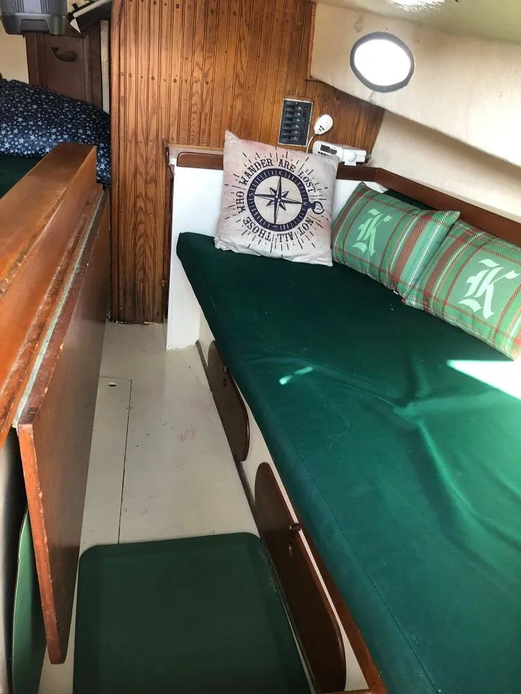 Slide: The Image of 1977 Marshall 22 boat interior with green cushions and nautical-themed decor. - 3
