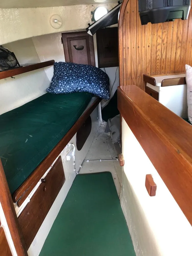 Slide: The Image of 1977 Marshall 22 boat interior with green cushions and wooden accents. - 4