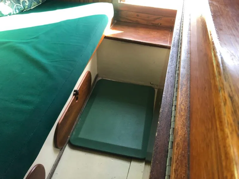 Slide: The Image of Cozy cabin interior of a 1977 Marshall 22 sailboat with green cushions. - 5