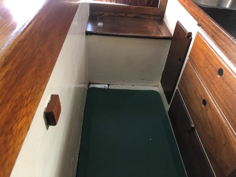 Slide: The Image of 1977 Marshall 22 interior with wooden cabinetry and green cushioned seating. - 6