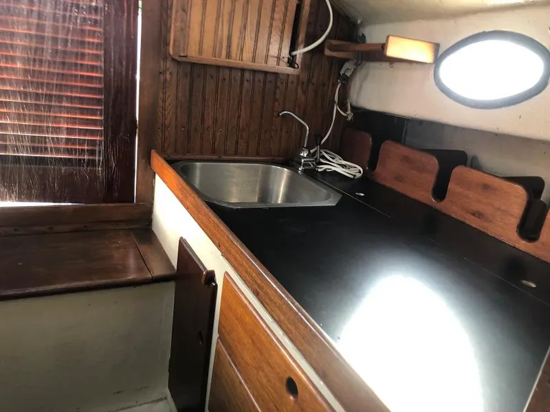 Slide: The Image of 1977 Marshall 22 boat interior with wooden cabinetry and stainless steel sink. - 7