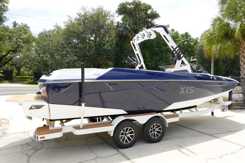 Slide: The Image of 2023 Axis A24 boat on trailer, sleek design, blue and white color scheme. - 10