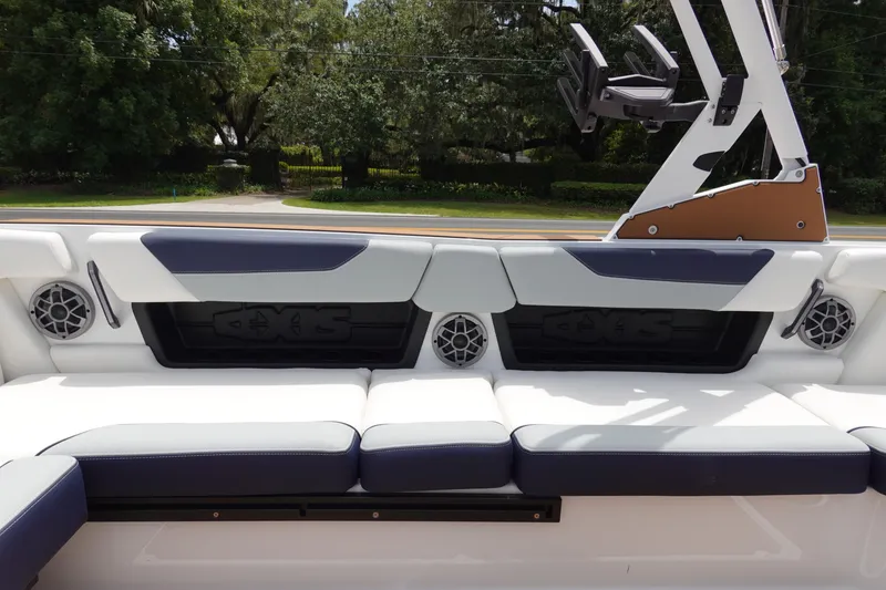 Slide: The Image of 2023 Axis A24 boat interior with cushioned seating and built-in speakers. - 16