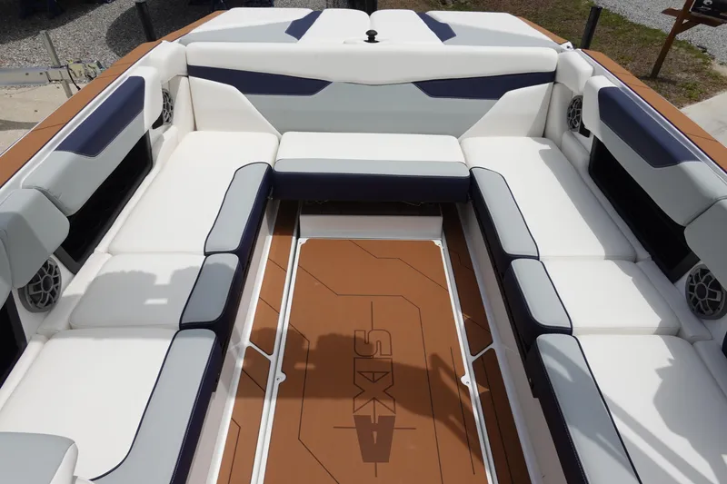 Slide: The Image of 2023 Axis A24 boat interior with white and navy seating, brown flooring. - 17