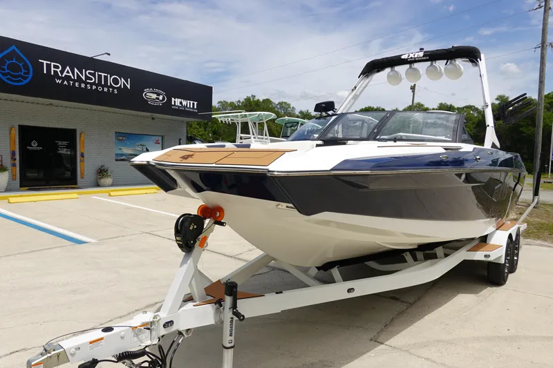 Slide: The Image of 2023 Axis A24 boat on trailer at Transition Watersports dealership. - 2
