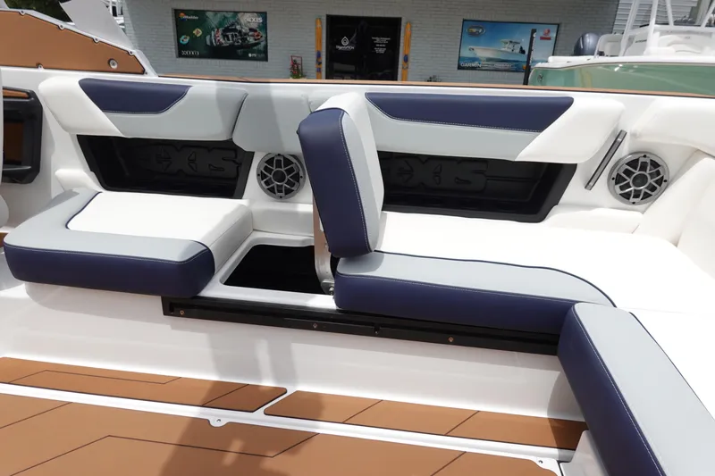Slide: The Image of 2023 Axis A24 boat interior with blue and white seating and built-in speakers. - 28