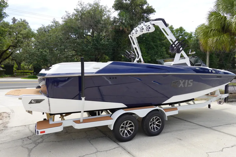 Slide: The Image of 2023 Axis A24 boat on trailer, sleek design, blue and white color scheme. - 5