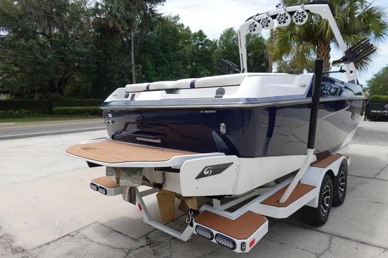 Slide: The Image of 2023 Axis A24 boat on trailer, rear view, parked outdoors. - 6
