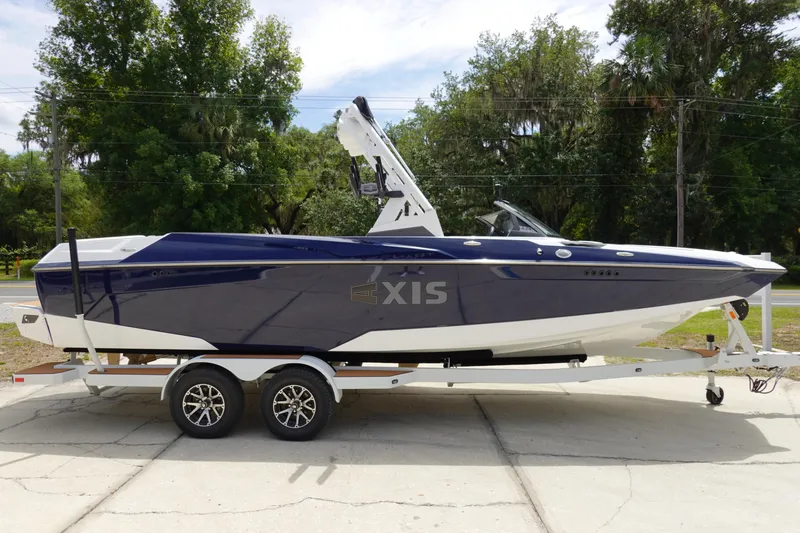 Slide: The Image of 2023 Axis A24 boat on trailer, sleek design, blue and white color scheme. - 9