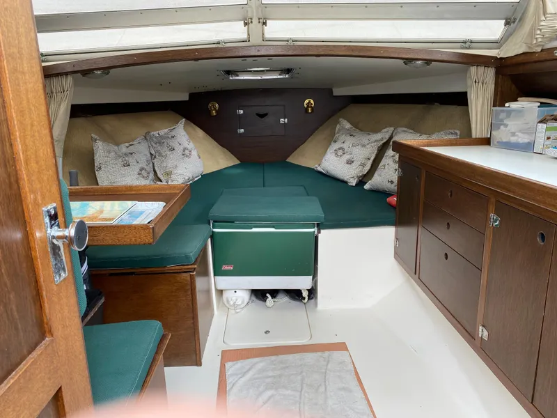 Slide: The Image of 1975 Bertram 28 Flybridge cabin interior with seating, cushions, and storage. - 2