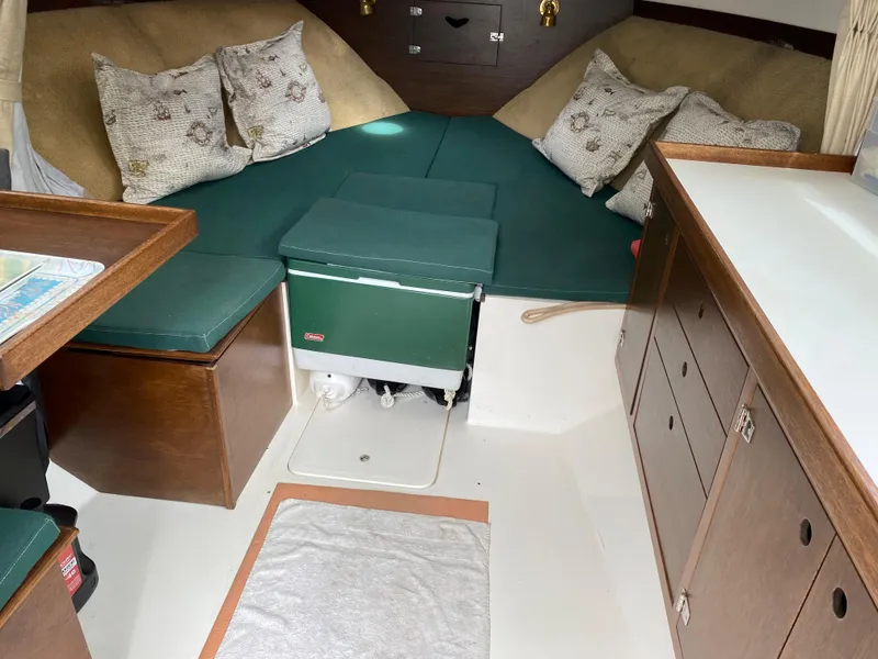 Slide: The Image of Interior of a 1975 Bertram 28 Flybridge boat with green cushions and wooden cabinetry. - 20