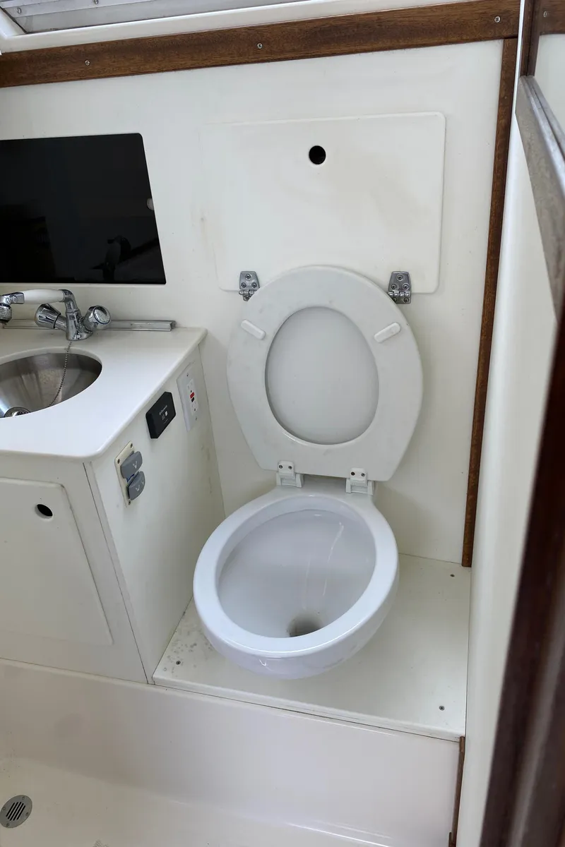 Slide: The Image of 1975 Bertram 28 Flybridge boat bathroom with toilet and sink. - 26