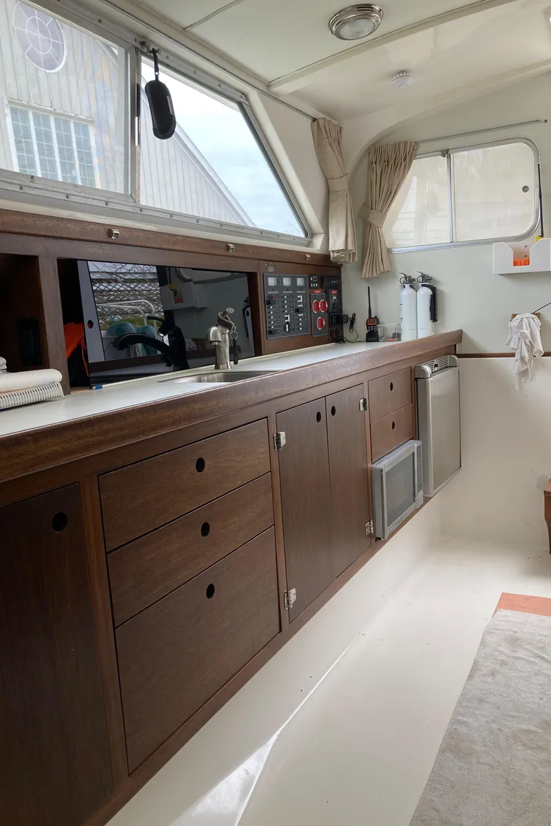 Slide: The Image of 1975 Bertram 28 Flybridge interior with wooden cabinetry and modern appliances. - 30