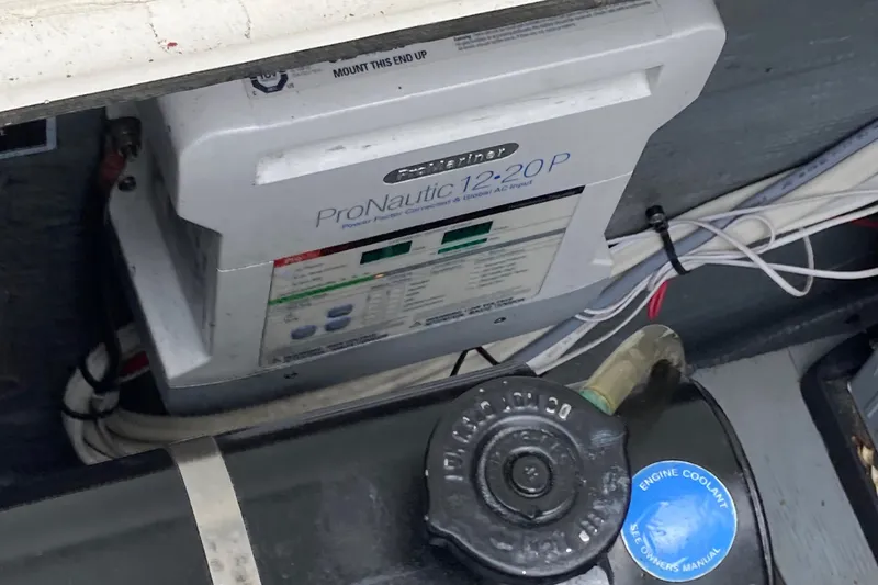 Slide: The Image of 1975 Bertram 28 Flybridge engine compartment with ProNautic 12-20P charger and engine coolant cap. - 33