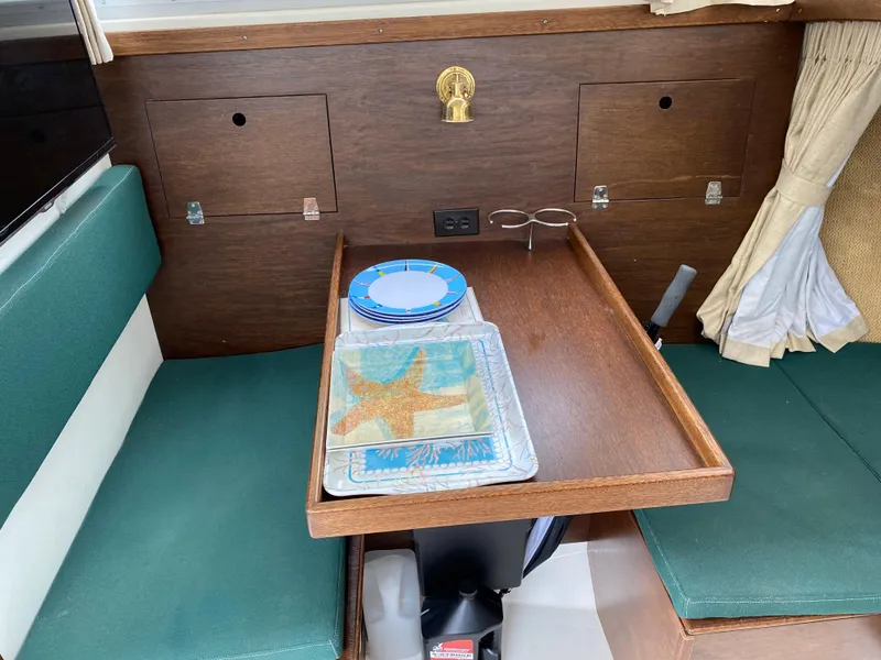 Slide: The Image of 1975 Bertram 28 Flybridge interior with dining table and starfish-themed plates. - 4