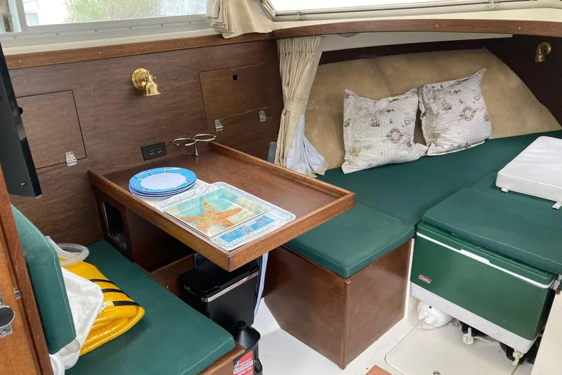 Slide: The Image of 1975 Bertram 28 Flybridge interior with green seating, table, and nautical decor. - 5