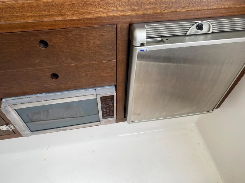 Slide: The Image of 1975 Bertram 28 Flybridge galley with microwave and refrigerator. - 8