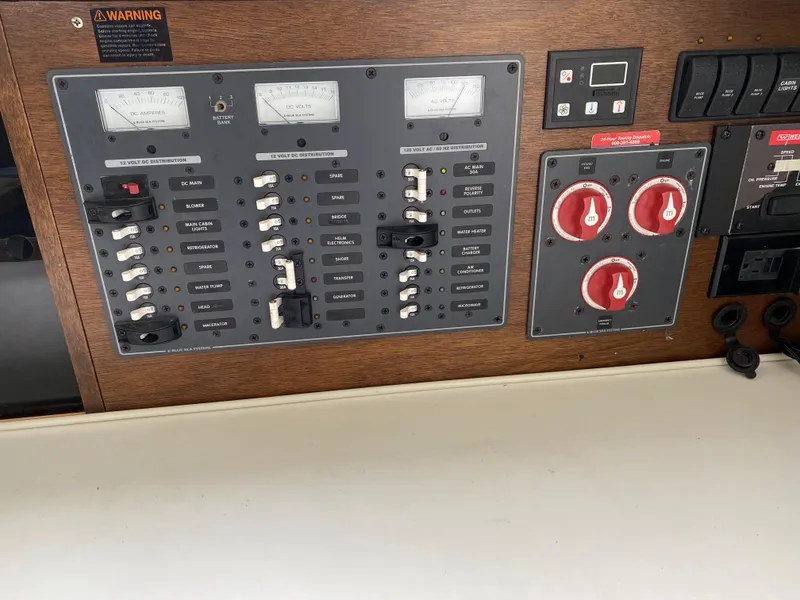 Slide: The Image of 1975 Bertram 28 Flybridge electrical control panel with switches and gauges. - 9