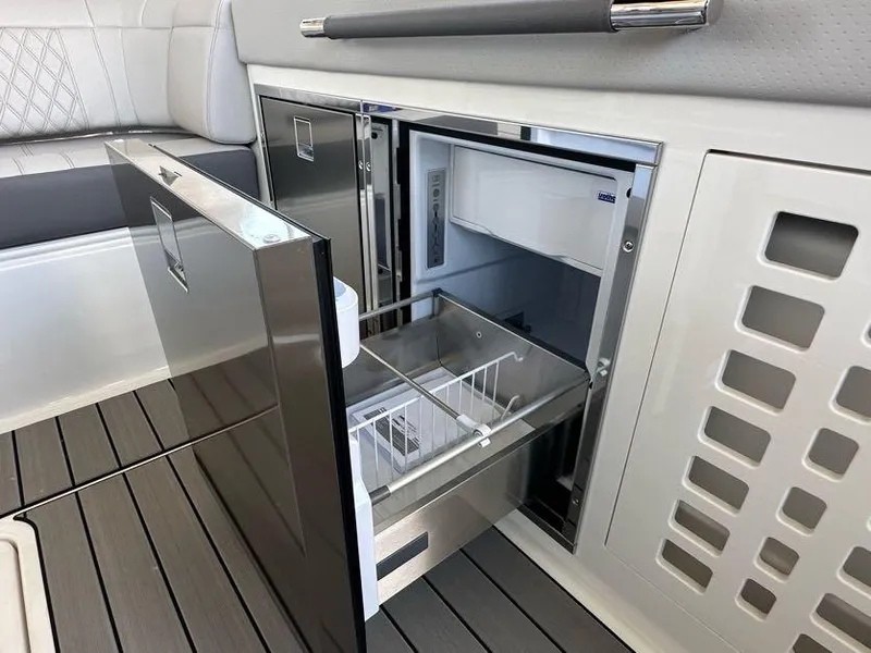 Slide: The Image of 2023 Sea Ray SLX 400 OB boat interior with open refrigerator drawer. - 13