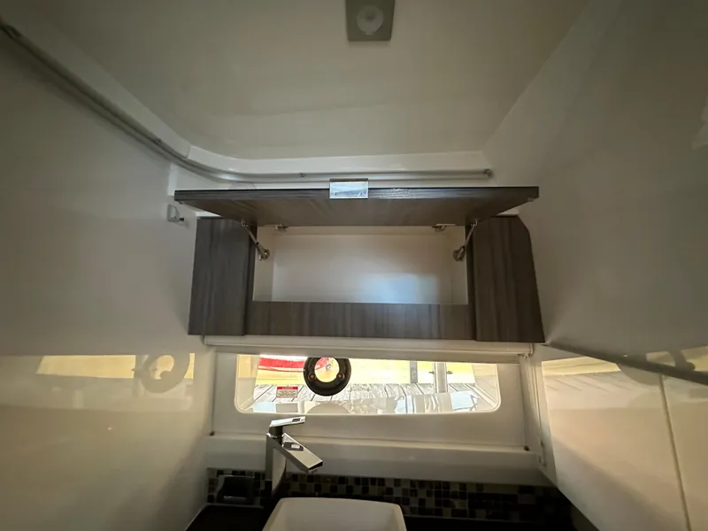 Slide: The Image of Interior of 2023 Sea Ray SLX 400 OB with modern cabinetry and window. - 23