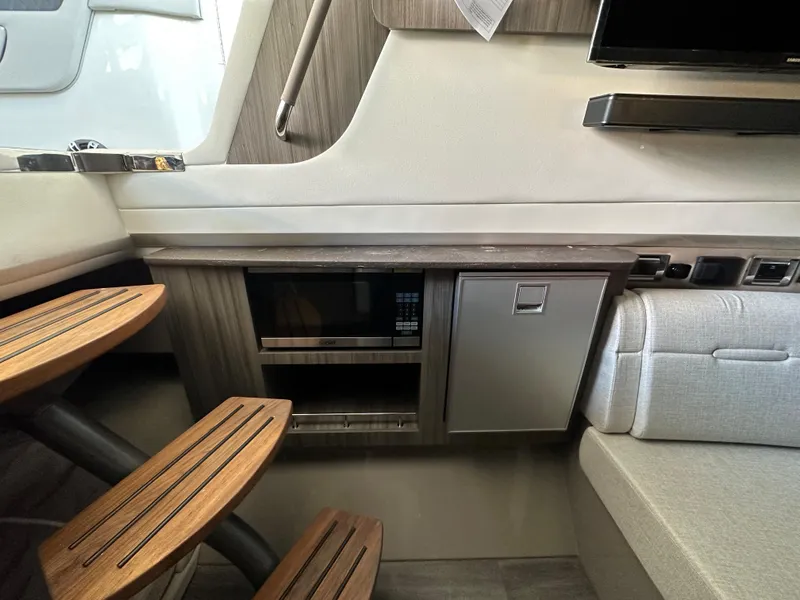 Slide: The Image of Interior of 2023 Sea Ray SLX 400 OB with wooden steps and built-in microwave. - 24