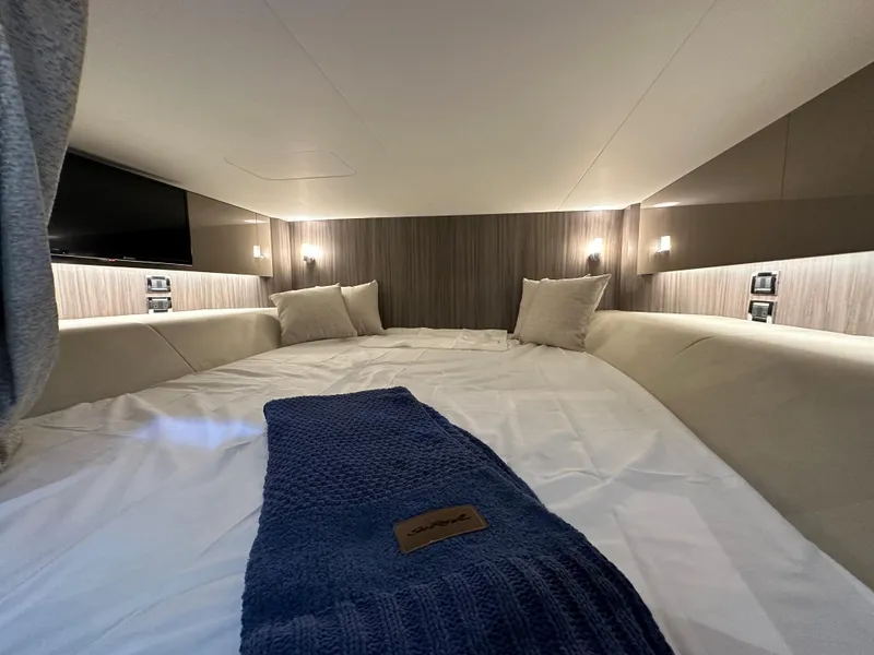 Slide: The Image of Luxurious cabin interior of 2023 Sea Ray SLX 400 OB with cozy bedding and ambient lighting. - 30
