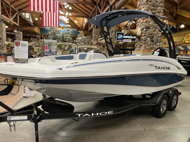 Slide: The Image of 2023 Tahoe 1950 boat on display in showroom with American flag in background. - 2