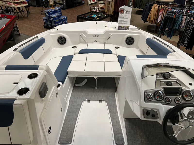Slide: The Image of 2023 Tahoe 1950 boat interior with white and blue seating, dashboard, and cup holders. - 6