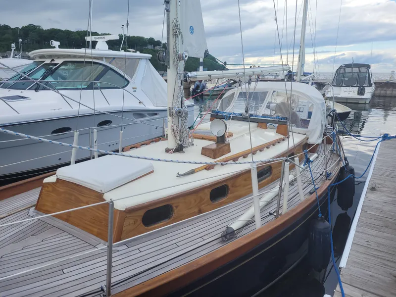 Slide: The Image of 1969 Allied Seabreeze 35 sailboat docked at marina, featuring classic wooden deck design. - 2