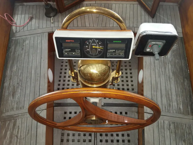 Slide: The Image of 1969 Allied Seabreeze 35 sailboat helm with wooden wheel and navigation instruments. - 22