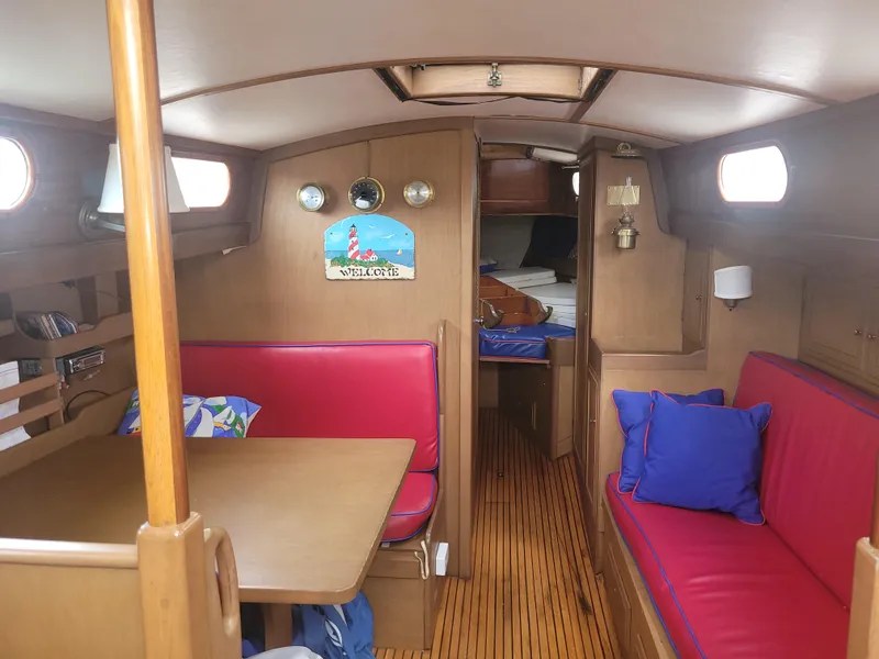 Slide: The Image of Interior of 1969 Allied Seabreeze 35 sailboat with red seating and wooden accents. - 25