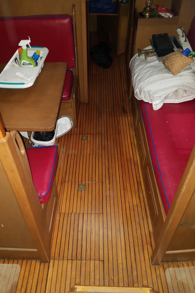 Slide: The Image of Interior of a 1969 Allied Seabreeze 35 sailboat with wooden flooring and red seating. - 33