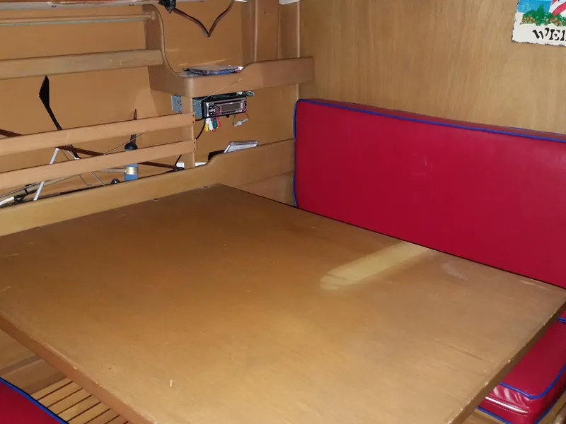 Slide: The Image of Interior of 1969 Allied Seabreeze 35 sailboat with wooden table and red cushioned seating. - 35