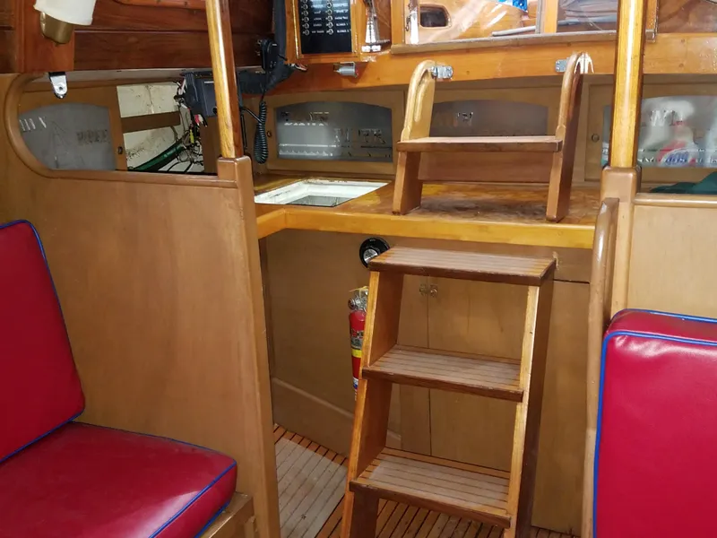 Slide: The Image of Interior of 1969 Allied Seabreeze 35 sailboat with wooden steps and red cushioned seating. - 36