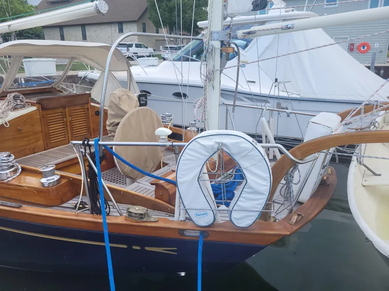 Slide: The Image of 1969 Allied Seabreeze 35 sailboat docked, featuring wooden deck and life preserver. - 8