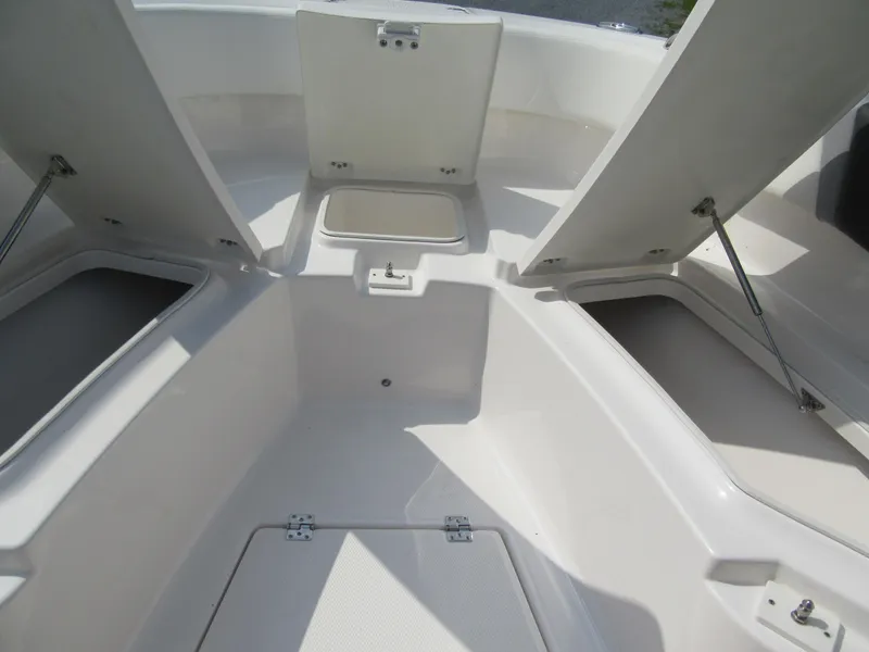 Slide: The Image of 2023 Robalo R250 CC boat storage compartments open. - 11