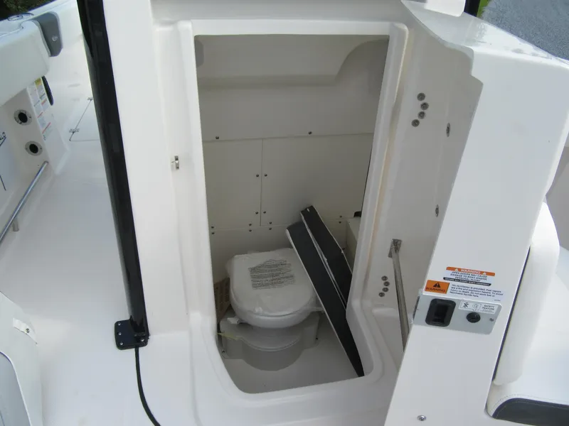 Slide: The Image of 2023 Robalo R250 CC boat interior with a compact marine toilet. - 14